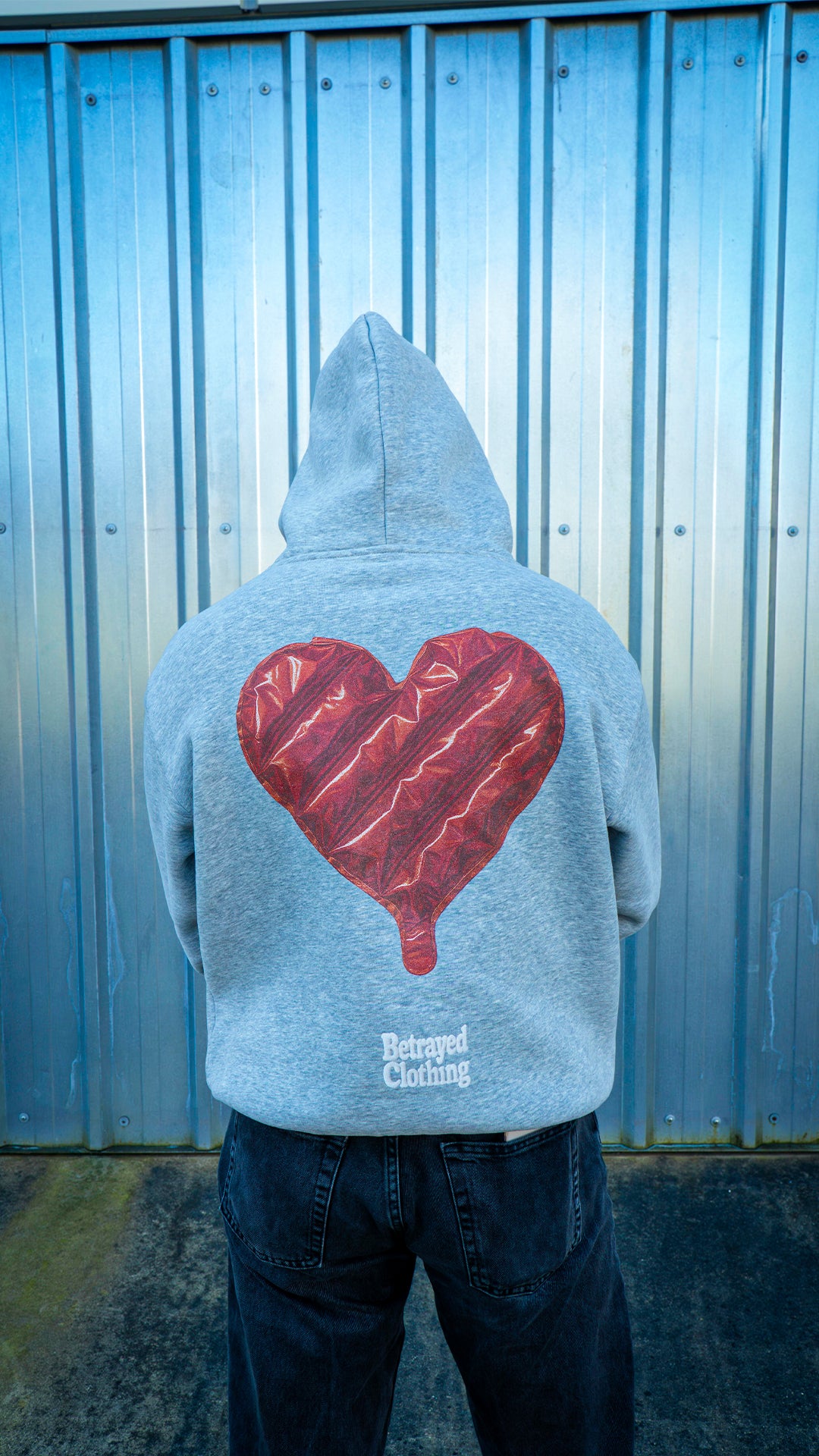 Modelo vistiendo sudadera gris oversize estilo urbano de la marca Betrayed Clothing.